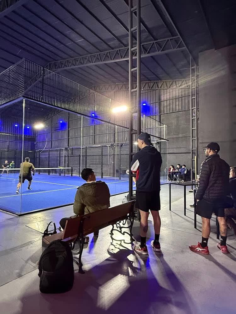 Gente mirando un partido desde el costado de la cancha