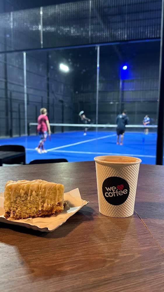 Café en la barra de la cantina con un partido de fondo